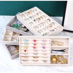 Detail view of multi-compartment jewelry organizer trays in beige and grey velvet