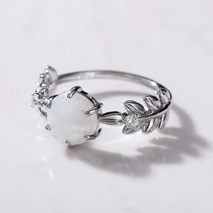 Dettaglio macro di un anello in argento a forma di foglia con opale bianco tondo
