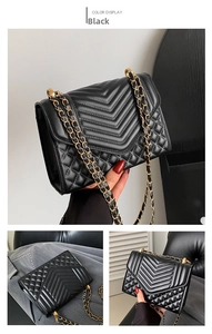 Detailed view of black faux leather crossbody bag with V-quilted pattern and gold chain