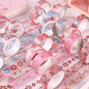Close-up of pink and blue cherry blossom washi tape rolls for scrapbooking and gifts