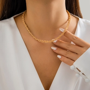 Close-up of layered gold twisted chains on a woman's neck for a minimalist elegant style