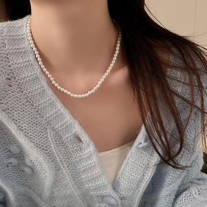 Gros plan d'un élégant collier de grandes perles blanches porté par un mannequin