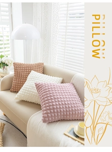 Detailed texture of waffle weave decorative pillows in brown, white and pink on a sofa