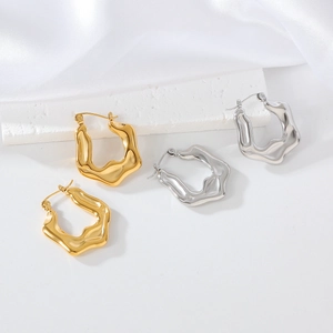 Macro shot of wavy irregular geometric earrings in polished gold and silver finishes