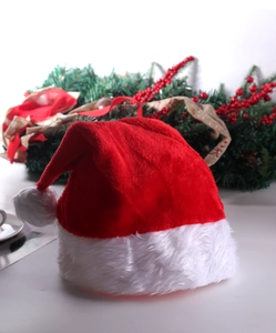 Detail of plush red Christmas hat with white faux fur trim and fluffy pom-pom decoration