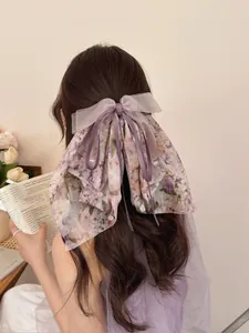 Dettaglio molletta per capelli a fiocco floreale viola con strati in chiffon e perle