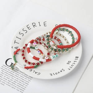 Detailed view of Christmas layered beaded bracelets with Santa charms and Merry letters