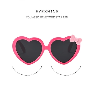 Detail of rose pink heart-shaped sunglasses with cute bow accent for girls' eye protection