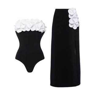One-shoulder black swimsuit with 3D white flower petal appliques and high waist skirt