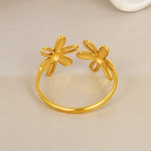 Detail of gold double flower open ring with delicate hollow petals on textured fabric