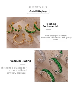 Détail des boucles d'oreilles créoles en C avec zircons verts et finition dorée polie