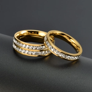 Two-piece set of rose gold stainless steel rings with sparkling crystals on black display