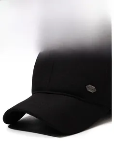 Detail of black winter baseball cap showing thick brim and diamond-shaped metal emblem