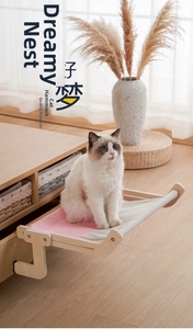 Detail of wooden cat window hammock with a cat sitting on a pink fabric bed surface