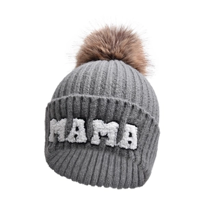 Dettaglio del ricamo MAMA su cappello grigio in maglia con pompon in ecopelliccia