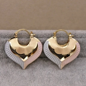 Three-tone heart hoop earrings in gold silver and rose gold finishes with radial texture