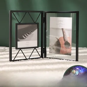 Close-up of black metal bifold photo frame with colorful LED fairy lights and glass panels
