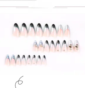 Detailed view of almond-shaped press-on nails with silver stars and rhinestone accents