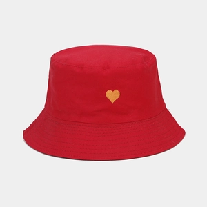Détail du chapeau bob en coton rouge avec broderie coeur jaune vif soignée