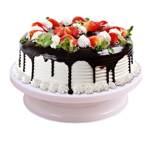 Pink rotating cake turntable with chocolate strawberry cake on a clean white background