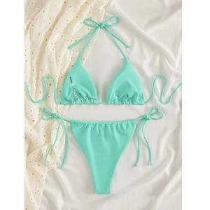 Detailed view of mint green bikini set featuring neck ties and ribbed fabric texture