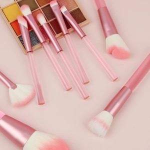 Flat lay of 9 pink transparent handle makeup brushes with soft gradient bristles