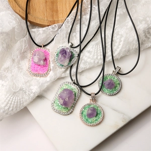 Detailed macro view of geometric amethyst pendant necklaces with sparkling crystal borders