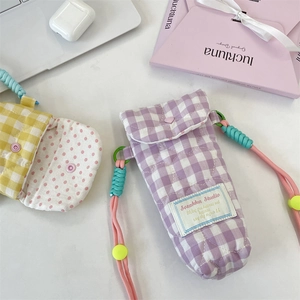 Detail of quilted gingham crossbody phone and camera pouches in purple and yellow