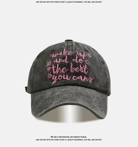Close-up of pink embroidery on dark grey washed cotton baseball cap with floral details