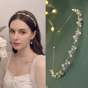 Dettaglio del cerchietto floreale con foglie di opale e strass indossato da modella