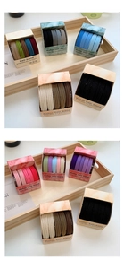 Macro detail of high-elasticity hair ties in assorted candy colors with minimalist box