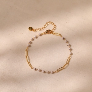 Detail of paperclip chain bracelet with white beads and metallic disc pendant
