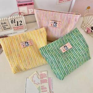 Détails de trousses à maquillage en tweed avec écussons panda en rose, jaune et vert
