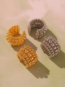 Detailed macro view of four-row metal bead ear cuffs in polished gold and silver finishes