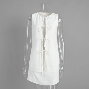 Detail of white two-piece set featuring bow-tie front sleeveless top and A-line mini skirt
