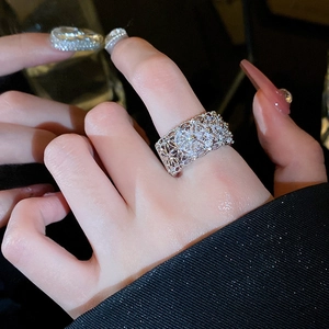 Close-up of wide silver ring with pavé zircons and intricate hollow floral details