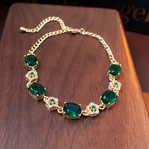 Luxurious gold plated flower bracelet with emerald stones and starburst diamond accents