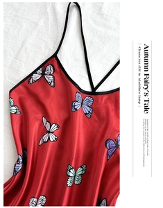 Detail of red satin nightgown with butterfly prints and thin black shoulder straps