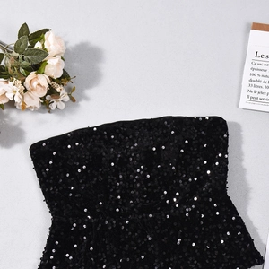 Flat lay of a sparkling black leopard sequin crop top with elegant floral decor