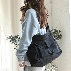 Japanese style black canvas messenger bag with multi-pocket design and wide shoulder strap