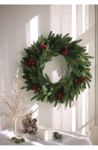 Close-up of a green Christmas wreath featuring natural pine cones and red berries on a wall