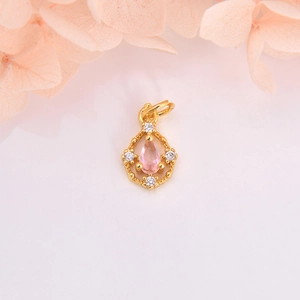 Detail of gold hollow pendant with pink teardrop gemstone and micro-pave crystals