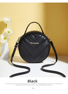 Detail of black V-quilted round crossbody bag with gold hardware and top handle
