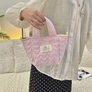 Detailed view of pink heart quilted tote with Happy patch and yellow handle