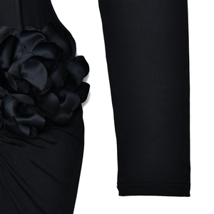Detail of a large 3D satin floral applique on a black high-neck evening dress