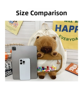 Detail view of plush Capybara backpack with clear PVC window and colorful pom-poms