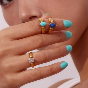 Detail of gold plated rings featuring turquoise, lapis lazuli and marquise zircon stones