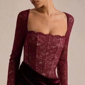 Close-up of elegant burgundy lace corset top with floral patterns and square neckline