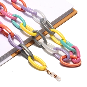Colorful oval acrylic link eyewear chain with gold metal clips on a white notebook