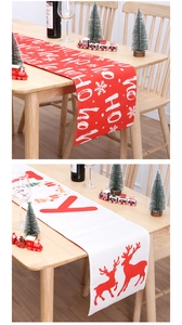 Close-up of festive Christmas table runners featuring Ho Ho Ho and Joy reindeer prints
